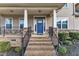 Inviting front entrance with brick steps, black iron railings, stone columns and a bright blue front door at 208 Tarkenton Ct, Clayton, NC 27527