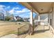 Spacious covered porch with stone-accented columns, black railings, and views of the surrounding neighborhood at 208 Tarkenton Ct, Clayton, NC 27527