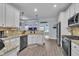 Modern kitchen with stainless steel appliances, granite countertops, white cabinets, and a view into the living room at 208 Tarkenton Ct, Clayton, NC 27527