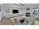 Bright living room features a fireplace, built-in shelving, large sectional and hardwood floors at 208 Tarkenton Ct, Clayton, NC 27527