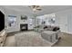 Cozy living room features a fireplace, windows, and a sectional sofa with neutral decor at 208 Tarkenton Ct, Clayton, NC 27527