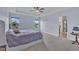 Spacious main bedroom featuring tray ceilings, a ceiling fan, and carpeted floors at 208 Tarkenton Ct, Clayton, NC 27527