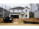 Unfinished two-story home exterior featuring a garage and covered entry with construction materials at 2130 Cherry Creek Rd, Haw River, NC 27258