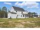 Side-rear exterior view of a two-story white home with a screened-in porch at 216 Meadow Walk Dr, Fuquay Varina, NC 27526