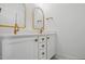 Bright bathroom features a white vanity with double sinks and modern gold-tone fixtures at 216 Meadow Walk Dr, Fuquay Varina, NC 27526