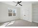 Bright bedroom with neutral carpet, a ceiling fan, closet, and a large window at 216 Meadow Walk Dr, Fuquay Varina, NC 27526