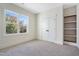 Bedroom featuring neutral carpet, white walls, large window with natural light and built-in shelving at 216 Meadow Walk Dr, Fuquay Varina, NC 27526