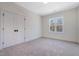 Bedroom featuring neutral carpet, white walls, double door closet and an exterior view from the window at 216 Meadow Walk Dr, Fuquay Varina, NC 27526