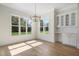 Bright dining area featuring a modern chandelier, built-in cabinets, and expansive windows offering natural light at 216 Meadow Walk Dr, Fuquay Varina, NC 27526