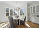 Bright dining area with a modern chandelier, large windows, and a built-in bar at 216 Meadow Walk Dr, Fuquay Varina, NC 27526