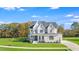 Stunning two-story white home with an attached garage, mature trees, and landscaping at 216 Meadow Walk Dr, Fuquay Varina, NC 27526