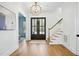Elegant foyer with hardwood floors, a stylish chandelier, and a staircase at 216 Meadow Walk Dr, Fuquay Varina, NC 27526