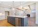 Kitchen island with stainless steel dishwasher and gold hardware is adjacent to living room with fireplace at 216 Meadow Walk Dr, Fuquay Varina, NC 27526