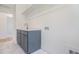 Laundry room sink with modern gold faucet, quartz countertop, blue-gray cabinets and overhead shelving at 216 Meadow Walk Dr, Fuquay Varina, NC 27526
