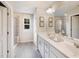 Bright bathroom featuring a double sink vanity, gray tile flooring, and glass enclosed shower at 231 Shingle Oak Rd, Wake Forest, NC 27587