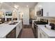 Open-concept kitchen with stainless steel appliances, white cabinets, and a view into the living room at 233 Shingle Oak Rd, Wake Forest, NC 27587