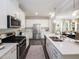 Bright kitchen featuring stainless steel appliances, white cabinets, a kitchen island, and sleek countertops at 233 Shingle Oak Rd, Wake Forest, NC 27587