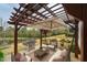 Outdoor living area features a pergola, grill, furniture set, and views of the beautiful backyard and pond at 237 Abercorn Cir, Chapel Hill, NC 27516