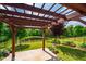 Backyard includes a stone patio with a pergola overlooking the pond and landscaped yard at 237 Abercorn Cir, Chapel Hill, NC 27516