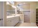 Bright bathroom featuring dual sinks, neutral-toned tiles, and a walk-in shower with grab bars for accessibility at 237 Abercorn Cir, Chapel Hill, NC 27516