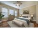Staged bedroom with hardwood floors, ceiling fan, and a large bed dressed with neutral linens at 237 Abercorn Cir, Chapel Hill, NC 27516