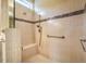 Close-up of walk-in shower featuring neutral-toned tiles, seating and grab bars for accessibility at 237 Abercorn Cir, Chapel Hill, NC 27516