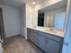 Bathroom featuring a double vanity with gray cabinets and a large mirror at 237 Shingle Oak Rd, Wake Forest, NC 27587