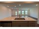 Modern kitchen island overlooking a living room area with wood floors and multiple windows at 237 Shingle Oak Rd, Wake Forest, NC 27587