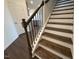 Elegant staircase with wood treads, wrought iron spindles, and freshly painted white risers at 237 Shingle Oak Rd, Wake Forest, NC 27587