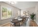 Dining area featuring a wooden table set for four, bright light, and a large window overlooking the exterior at 2416 Boothbay Ct, Raleigh, NC 27613