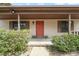 Inviting front porch featuring a brick landing and a vibrant red door, complemented by well-maintained landscaping at 2416 Boothbay Ct, Raleigh, NC 27613