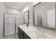 Modern bathroom with double sink vanity, quartz countertops, framed mirrors, and a glass-enclosed shower at 248 Shingle Oak Rd, Wake Forest, NC 27587