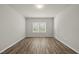 Empty bedroom featuring modern flooring, neutral walls, and a large window with blinds at 248 Shingle Oak Rd, Wake Forest, NC 27587