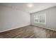 Inviting bedroom with wood-look flooring, neutral walls, and a large window offering natural light at 248 Shingle Oak Rd, Wake Forest, NC 27587