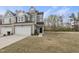 Charming gray townhome boasts an attached garage, manicured lawn, and inviting entryway, blending comfort and style at 248 Shingle Oak Rd, Wake Forest, NC 27587