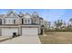 Townhouse featuring a two-car garage, gray siding, well-manicured front lawn, and natural wooded area in the back at 248 Shingle Oak Rd, Wake Forest, NC 27587