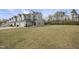 View of the townhouse property with expansive backyard, gray siding, and a backdrop of natural trees at 248 Shingle Oak Rd, Wake Forest, NC 27587