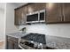 Close-up of a modern gas range stove with stainless steel accents, granite countertops, and tile backsplash at 248 Shingle Oak Rd, Wake Forest, NC 27587