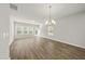 Bright, empty living room with wood floors, large windows, and modern lighting fixture at 248 Shingle Oak Rd, Wake Forest, NC 27587