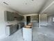 Open-concept kitchen layout, featuring gray cabinets, an island, and space for modern appliances at 249 Spilona Way # 64, Four Oaks, NC 27524