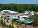 Aerial view of a community pool, pickleball courts, and recreational facilities surrounded by trees and homes at 249 Wendover Pkwy, Pittsboro, NC 27312