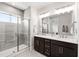 Modern bathroom featuring a glass-enclosed shower and a double vanity with dark wood cabinetry at 249 Wendover Pkwy, Pittsboro, NC 27312