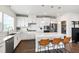 Gourmet kitchen featuring stainless steel appliances, white cabinets, quartz countertops, and eat-in island at 249 Wendover Pkwy, Pittsboro, NC 27312