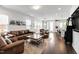 Open-concept living room with kitchen view, hardwood floors and comfortable leather seating at 249 Wendover Pkwy, Pittsboro, NC 27312