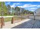 Large wooden back deck overlooking a yard, tall trees, and white picket fence at 274 Ashpole Trl, Clayton, NC 27520