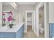Well-lit bathroom with blue vanity, quartz countertop, mirror, and walk-in closet at 274 Ashpole Trl, Clayton, NC 27520