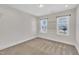 Empty bedroom features carpet, trim, two windows, and natural light at 274 Ashpole Trl, Clayton, NC 27520