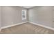 Neutral bedroom with a window offering outdoor views, carpet floors, and white trim at 274 Ashpole Trl, Clayton, NC 27520