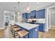 Kitchen island offers bar seating with white countertop and blue cabinets, open to dining area at 274 Ashpole Trl, Clayton, NC 27520