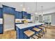 Kitchen island with breakfast bar features white countertops, blue cabinetry, and pendant lighting at 274 Ashpole Trl, Clayton, NC 27520